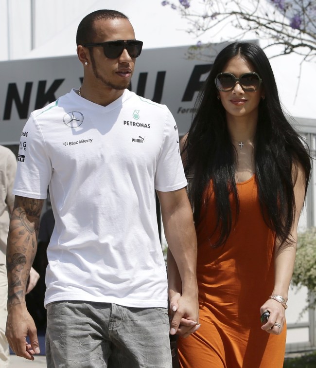 Mercedes Formula One driver Hamilton walks with girlfriend Scherzinger in the paddock before the start of the third practice session of the Malaysian F1 Grand Prix at Sepang International Circuit outside Kuala Lumpur